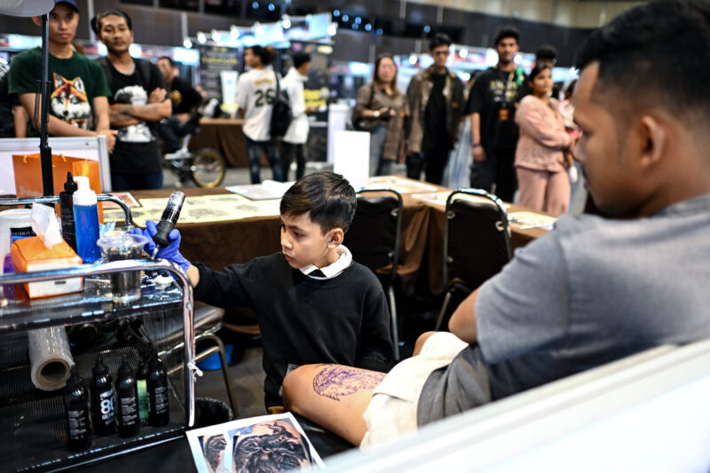 Niño tatuador de 9 años asombra por su destreza en Tailandia. Foto: AFP. 
