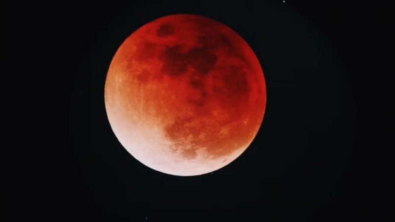 Cielo nocturno con la luna adquiriendo un tono rojizo durante el eclipse total